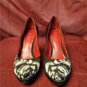 Heel shose white floral design on black background